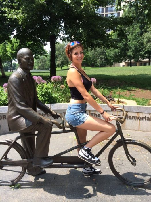 Chica en bici con estatua 