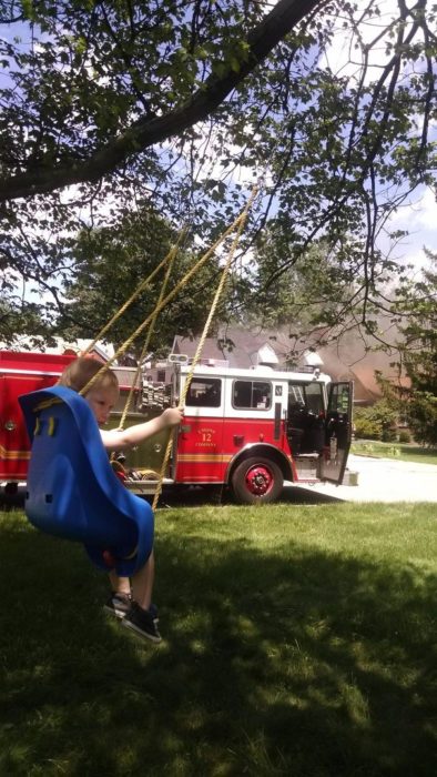 niña en el columpio y atrás hay un incendio 