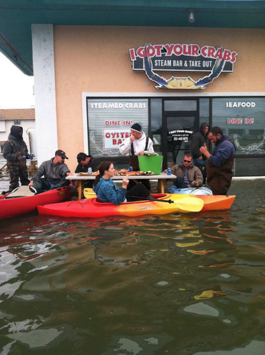 personas en kayak comiendo en medio de una inundación