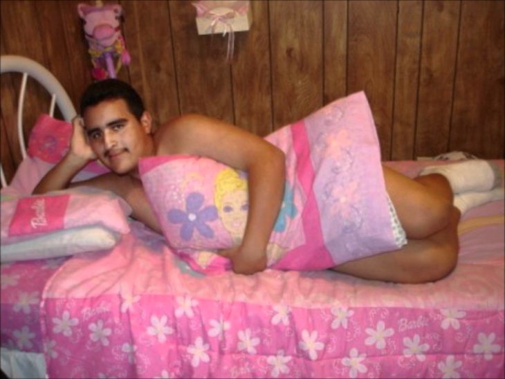 chico posando sexy con una almohada rosa