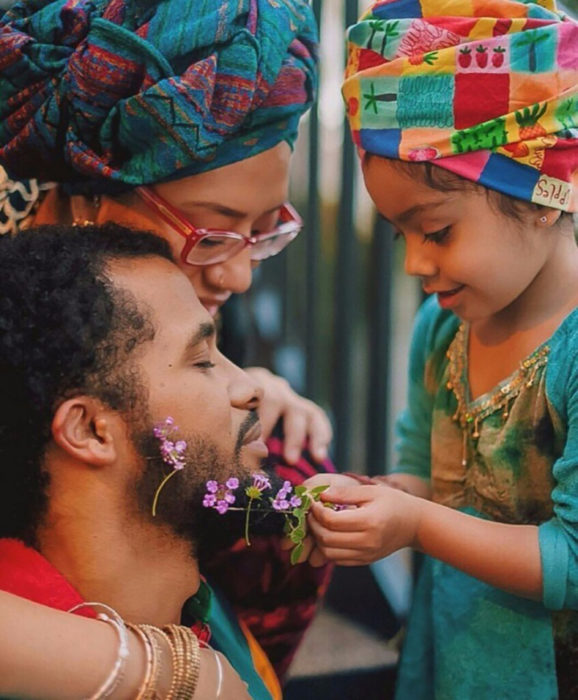 niña decorando con flores la barba de su papá