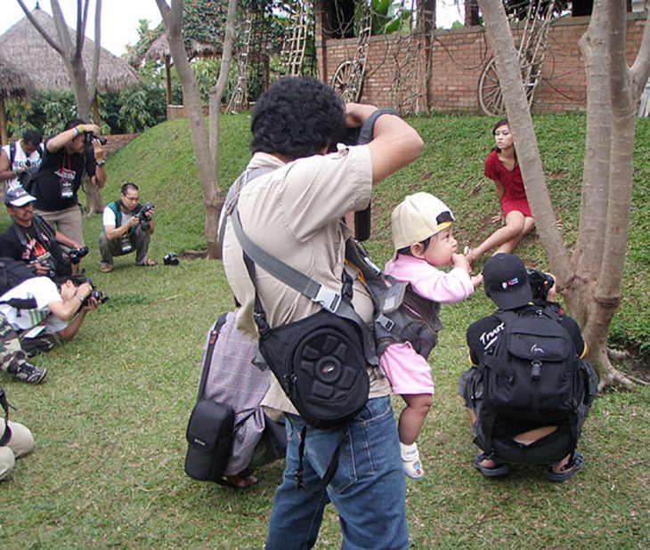 papá fotógrafo cargando a su bebé
