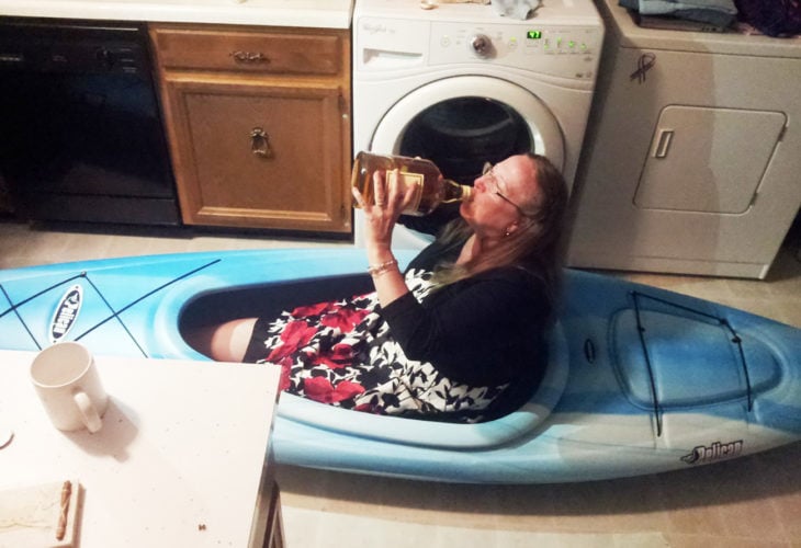 mujer en kayak tomando de una botella