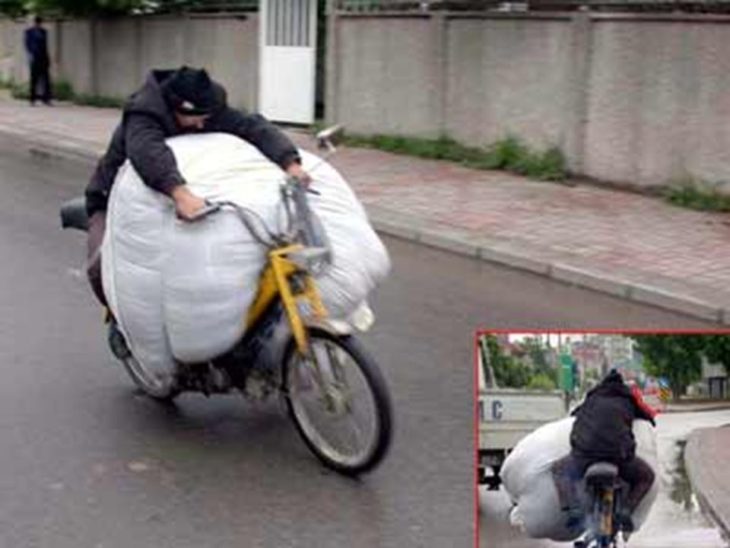 hombre lleva un gran paquete mientras va en su bicicleta