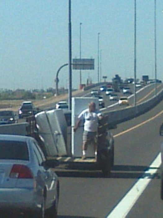 Hombre deteniendo electrodomésticos desde vehículo en movimiento