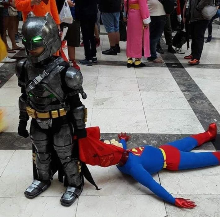 Niño disfrazado de Batman arrastrando a Spiderman 