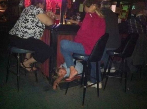 Mujer en el bar mientras su hijo duerme en el piso