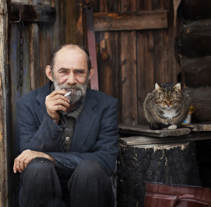 anciano fumando con su gato