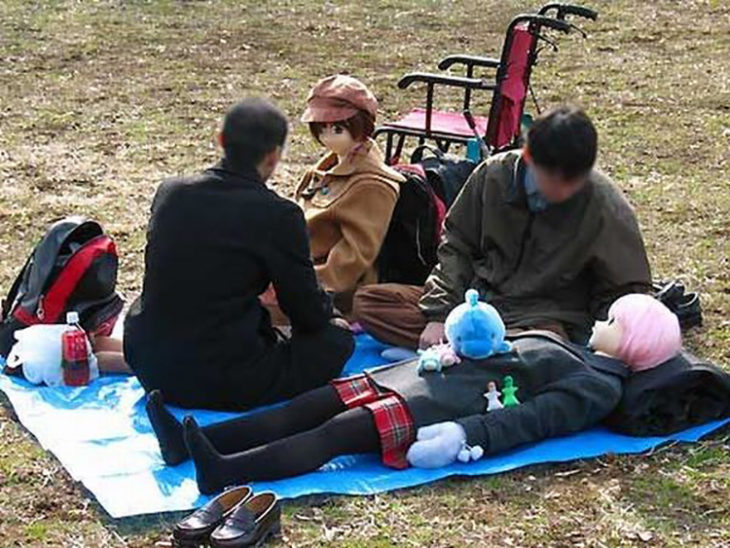 jóvenes en un parque con unas muñecas