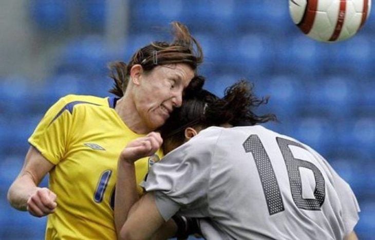 jugadoras de soccer chocan en disputa por el balón