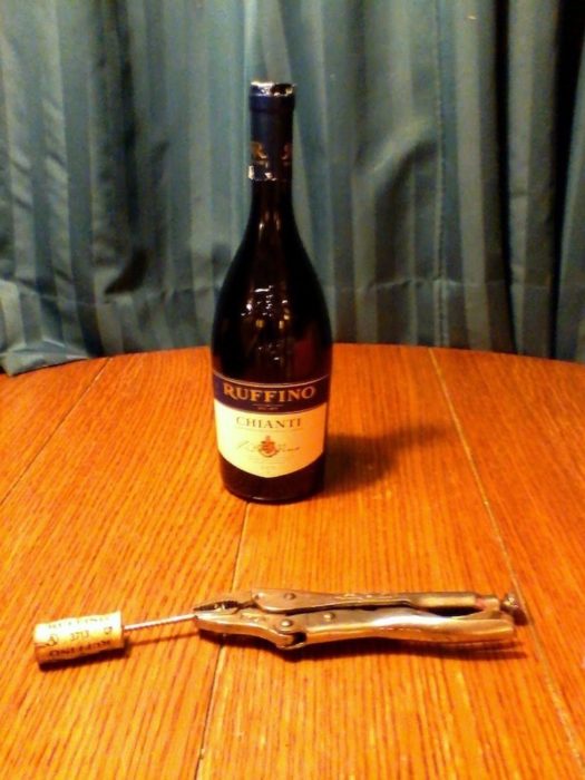 botella de vino abierta con una tornillo y pinzas