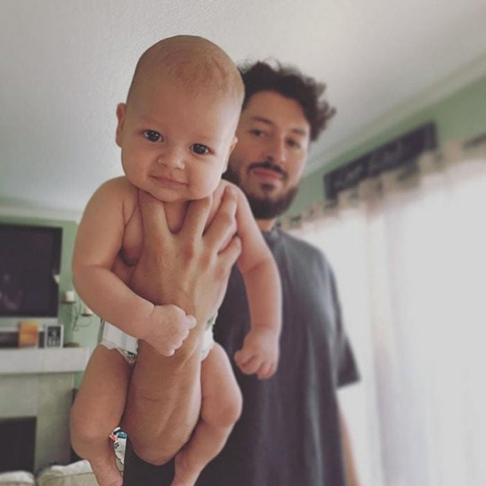 padre cargando a su bebé una mano