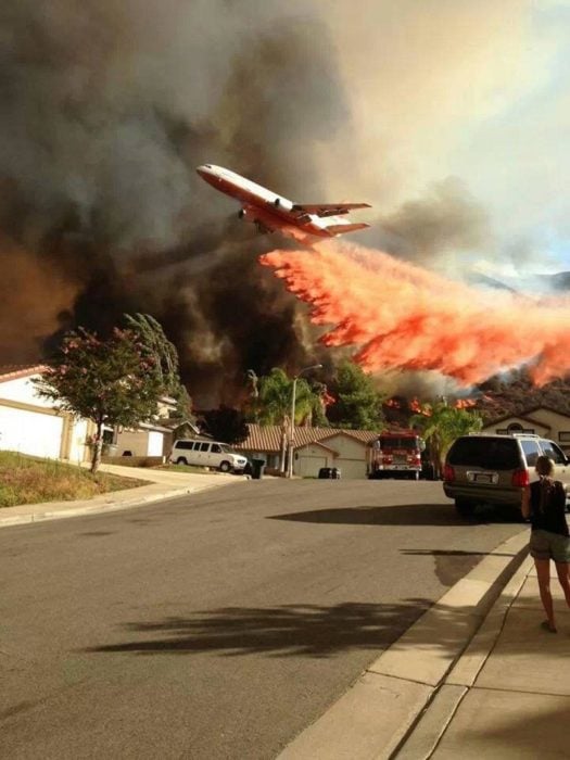 Avión pasando por bosque en fuego para apagarlo