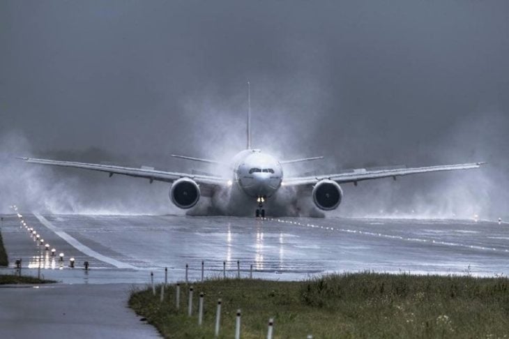 avión rodeado de agua mientras aterriza
