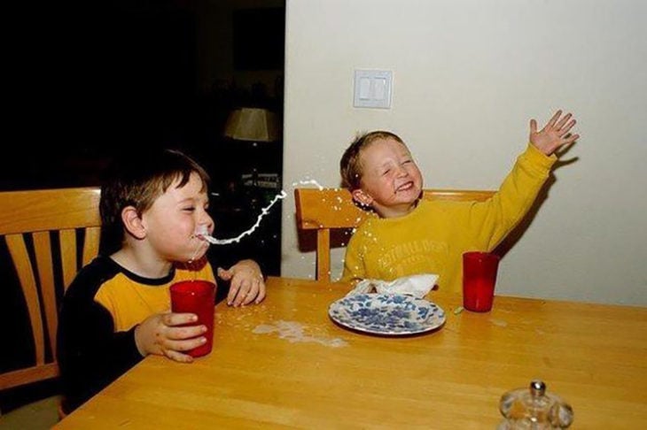 niño escupiendo leche mientras se ríe