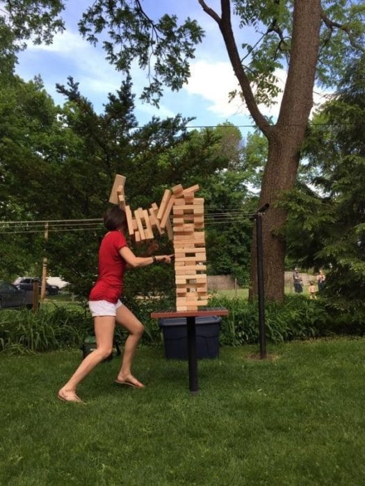 mujer se le caen encima grandes piezas de Jenga