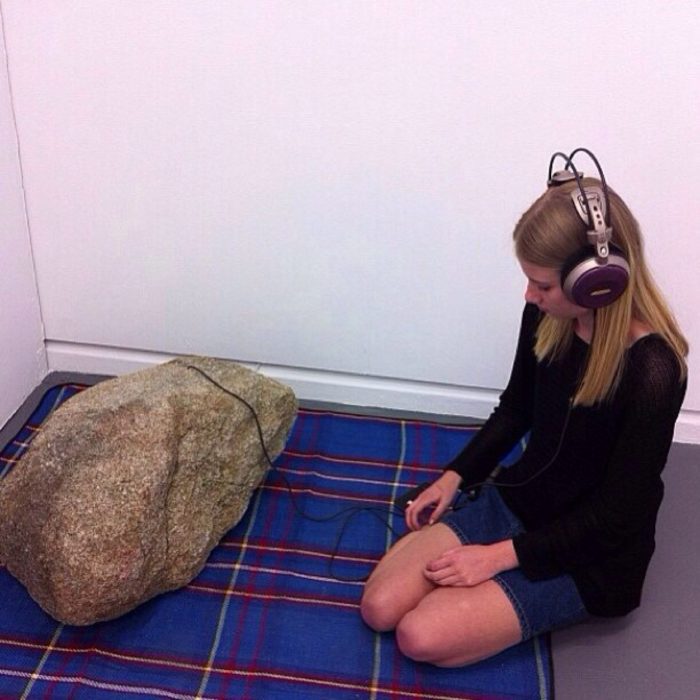 chica con una gran roca y audífonos