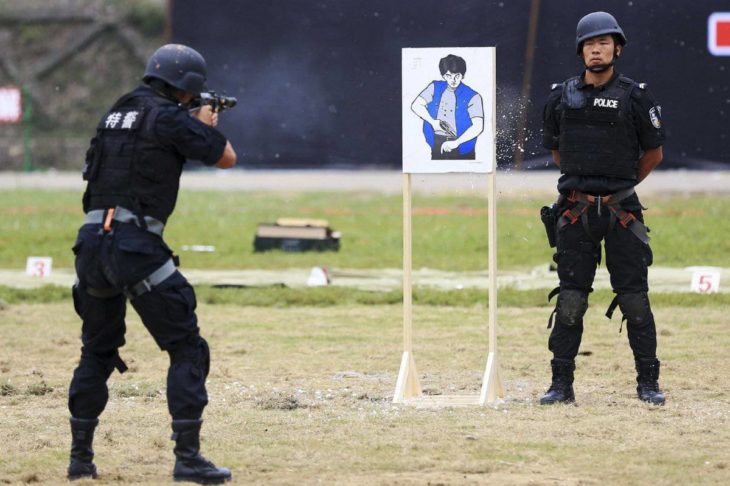 policías en campo de tiro uno de ellos distraído