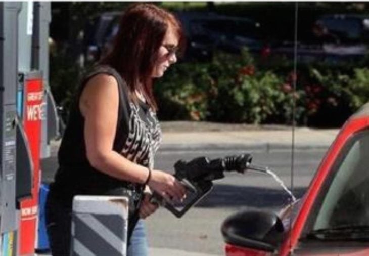 mujer en estación de gasolina haciéndolo mal