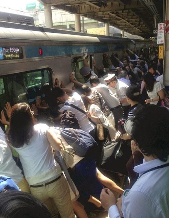 Personas empujando el metro