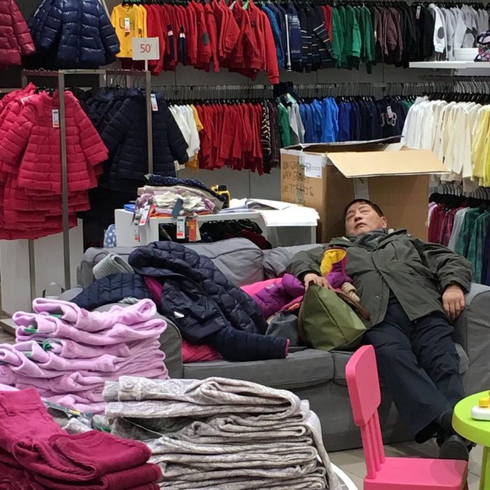 Hombre dormido en tienda de ropa de niños 