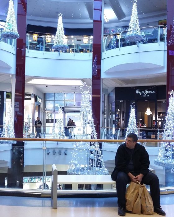 Hombre esperando a su espossa en centro comercial