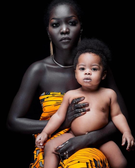 Hermosa modelo negra cargando a niño