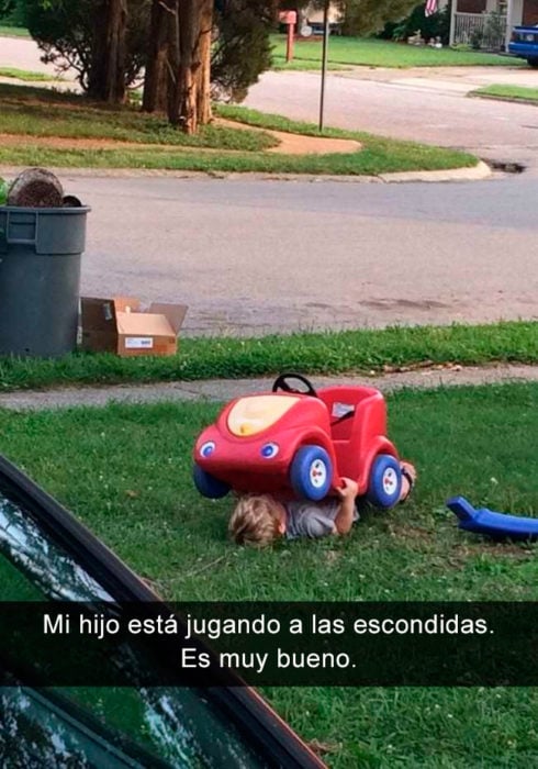 Niño debajo de su coche de juguete