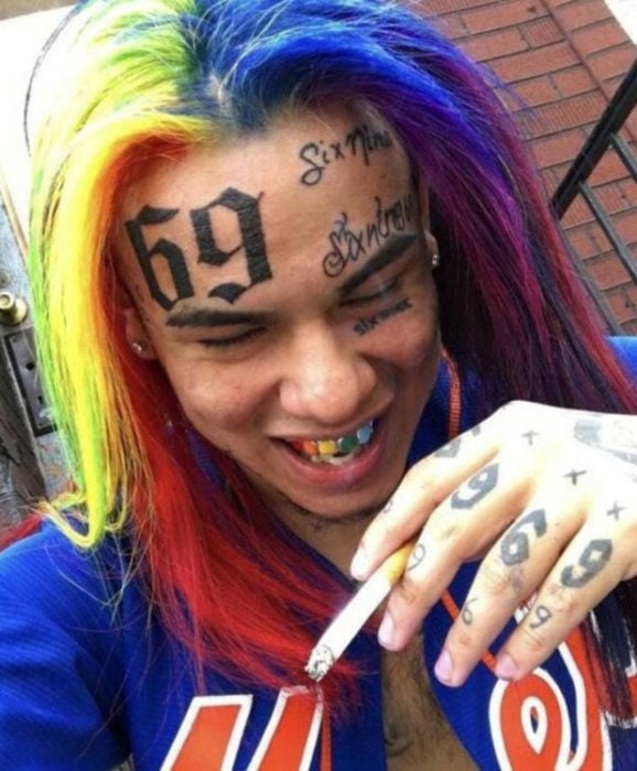 Hombre con tatuajes en la cara con el número 69