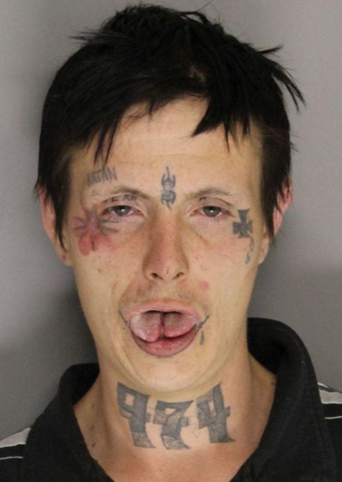 hombre con tatuajes extraños y lengua partida