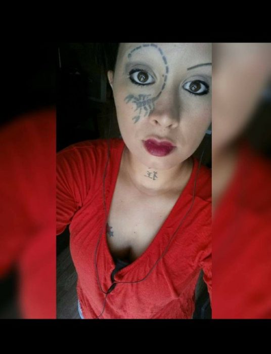 mujer con escorpión tatuado en la cara