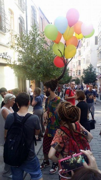 hombre con globos con helio en el cabello