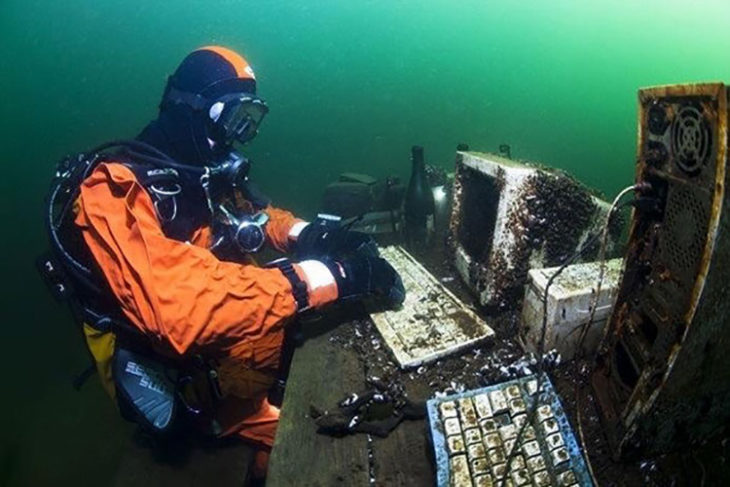 buzo dentro del agua con computadora