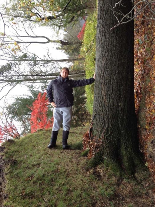 Joven posando en un árbol caído y simula fondo distrocionado