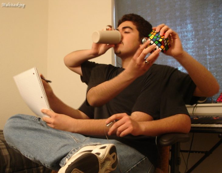 muchacho jugando cubo rubik y estudiando