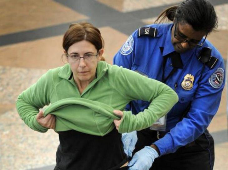 mujer en un aeropuerto siendo cacheada