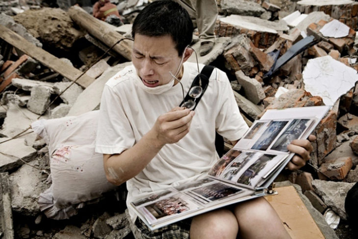 Hombre llora al ver el album familiar después de la muerte de ellos