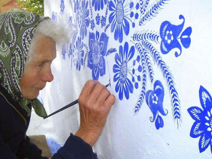 Anciana pinta casa a mano