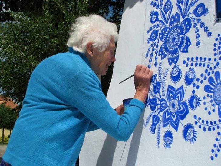Anciana pinta casa a mano