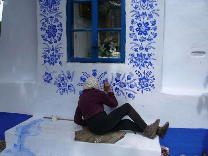 Anciana pinta casa a mano