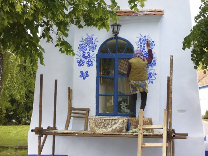 Anciana pinta casa a mano