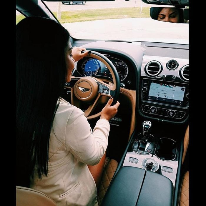 mujer manejando coche de lujo