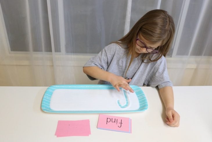 Niña escribiendo en sal