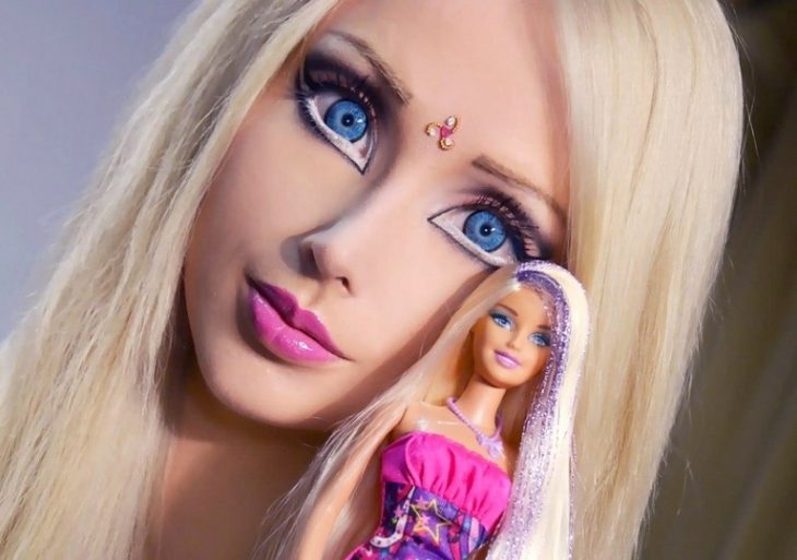 mujer de ojos azules sosteniendo una muñeca 