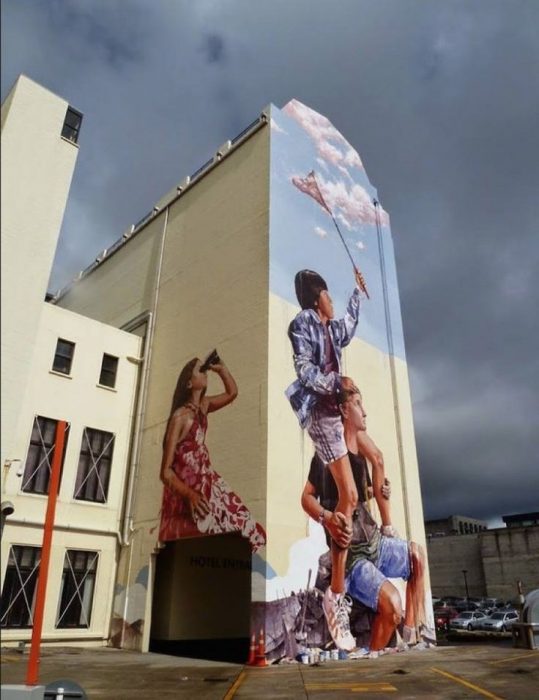 edificio con pintura de tres personas gigante