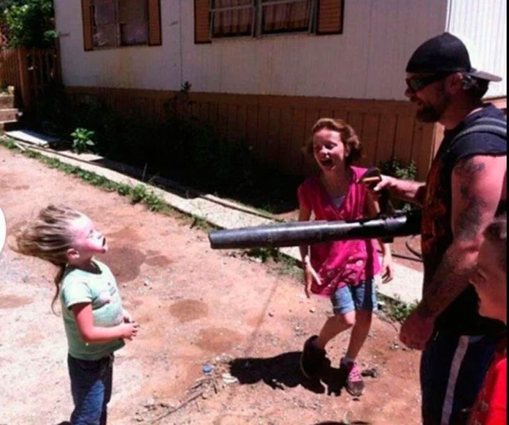 padre jugando con niñas arrojando aire