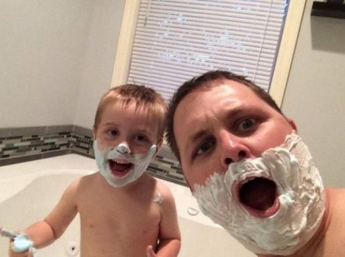hombre y niño con crema de afeitar en el rostro