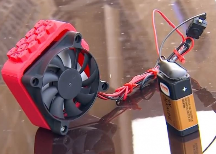 dispositivo color rojo con cables y pila