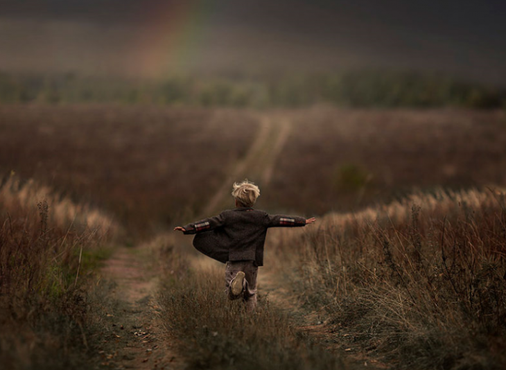 niño corriendo por la pradera