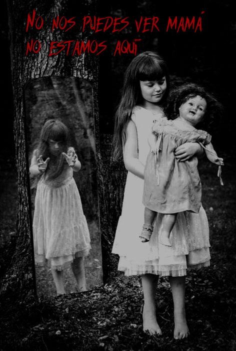 Imágen detenobroza de una niña, una muñeca y un espejo 